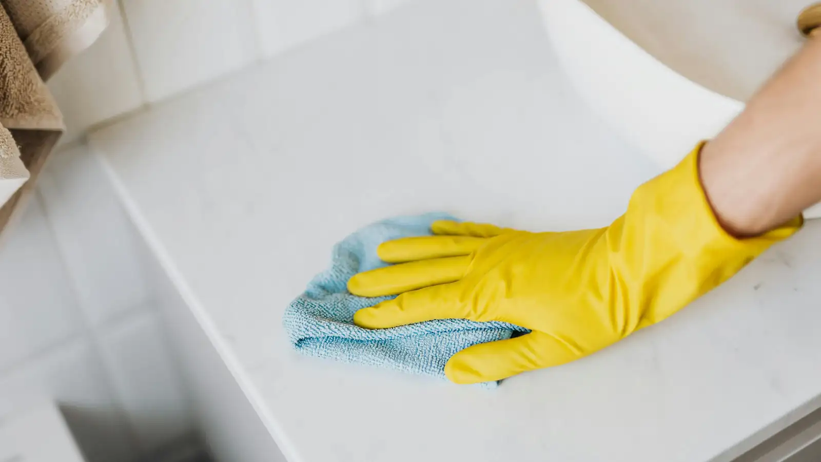 Hands cleaning an office desk